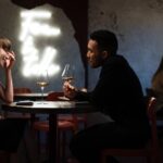 Man in Black Long Sleeve Shirt Sitting on Chair enjoying his first date with pretty lady