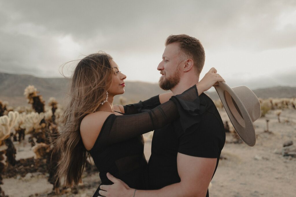 a man and a woman embracing in the desert